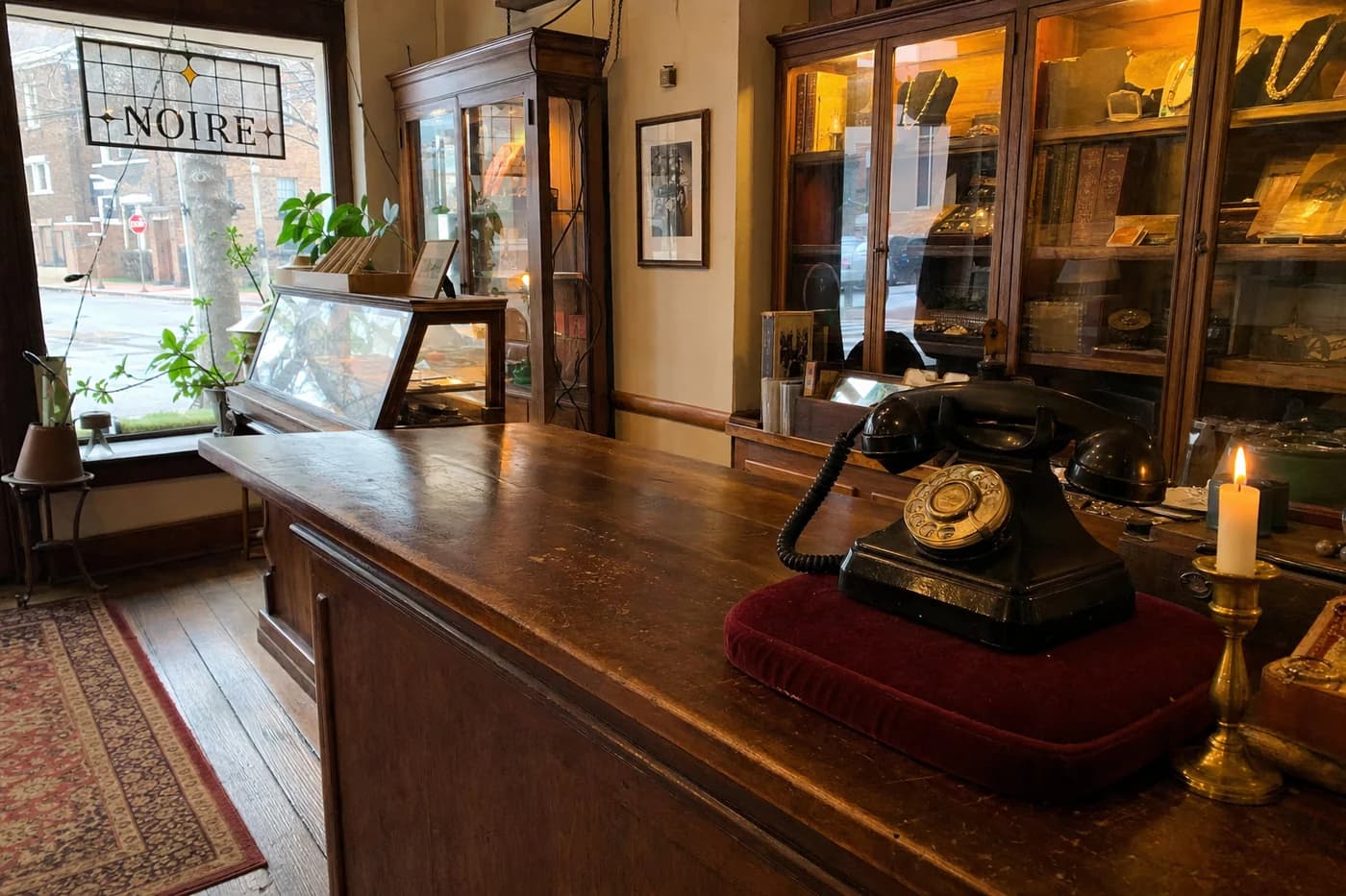 Rotary phone on a wine velvet pad inside Noire